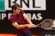 Taylor Fritz hits a backhand against Novak Djokovic